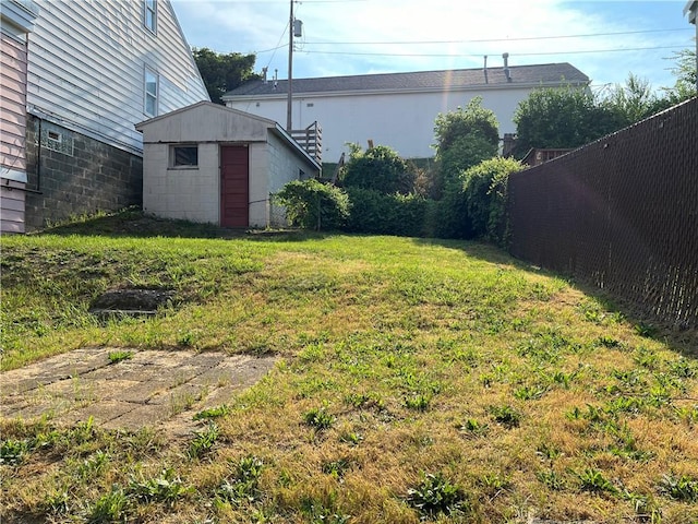 view of yard featuring an outdoor structure, a storage shed, and fence