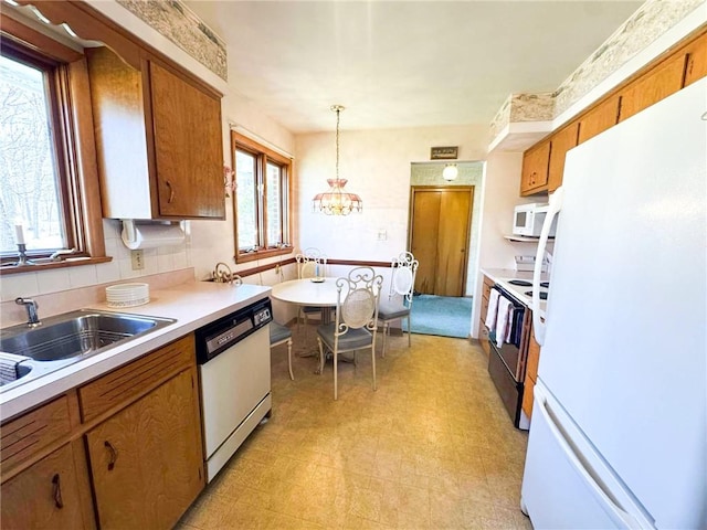 720 Dogwood Ln, Hermitage, PA 16148 - kitchen featuring white appliances, light countertops, a wealth of natural light, brown cabinets, and light floors