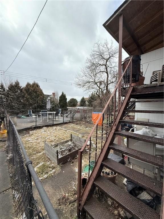 view of yard featuring stairs, fence, and a garden