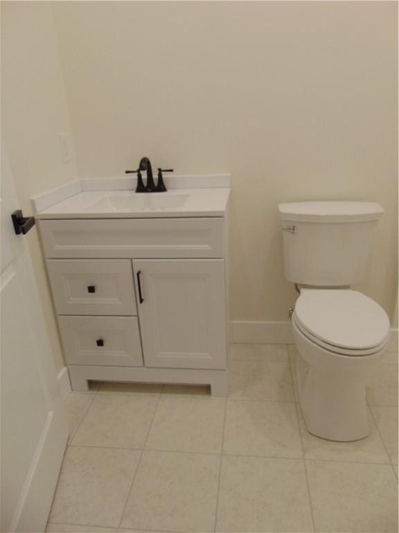 bathroom with baseboards, vanity, toilet, and tile patterned floors