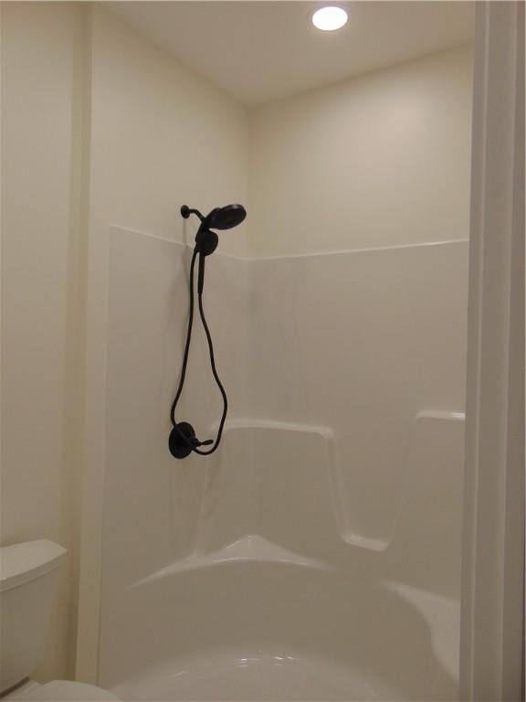 bathroom with recessed lighting, toilet, and walk in shower