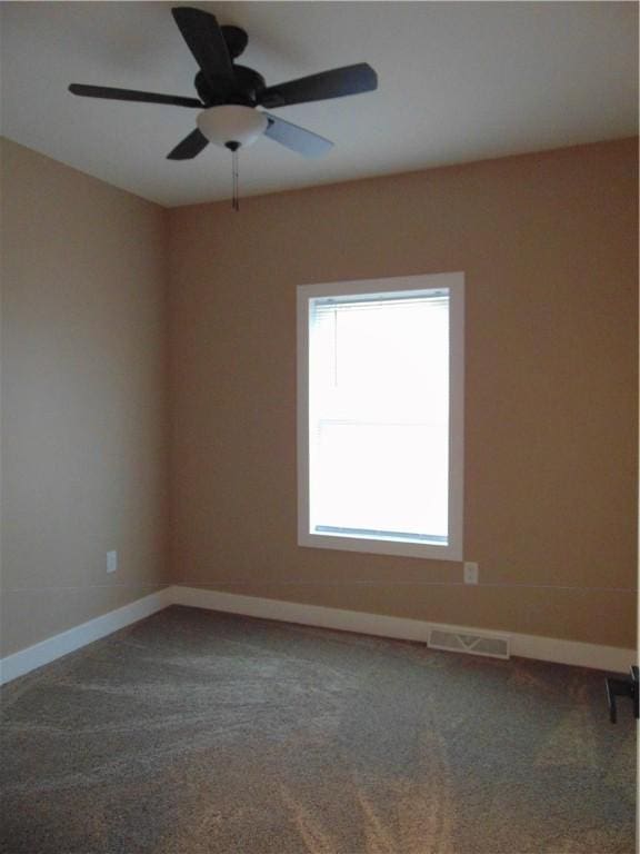 spare room featuring a ceiling fan, carpet, visible vents, and baseboards