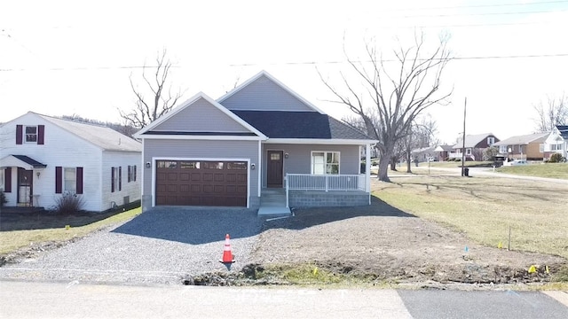 view of front of home with a garage, a porch, and gravel driveway