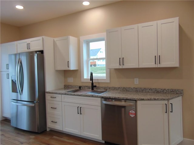 kitchen with stainless steel appliances, recessed lighting, white cabinetry, and a sink