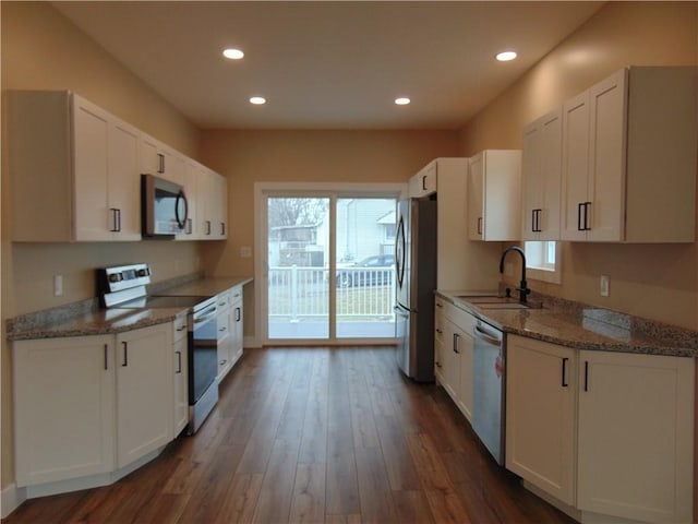 kitchen with white cabinets, appliances with stainless steel finishes, dark wood-type flooring, and a sink