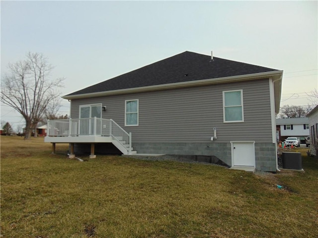 rear view of property featuring a lawn and a wooden deck