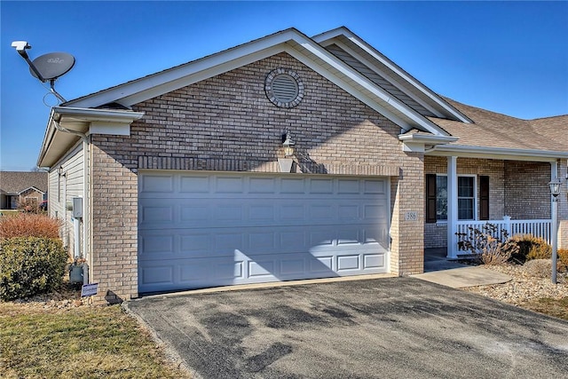 ranch-style house featuring covered porch, brick siding, a garage, and aphalt driveway