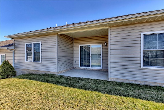 back of property featuring a patio and a lawn