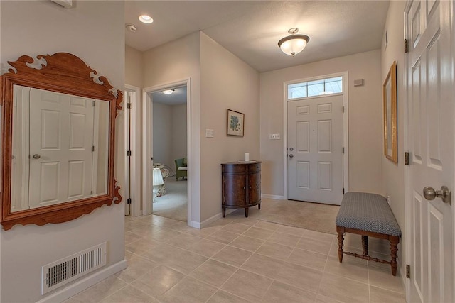 entryway featuring light tile patterned floors, visible vents, and baseboards