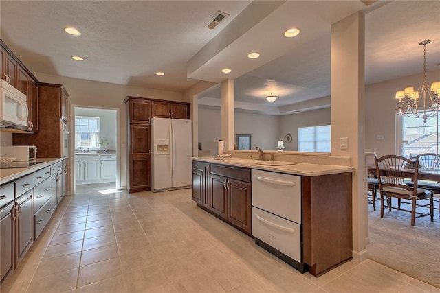 kitchen with light countertops, white appliances, visible vents, and plenty of natural light