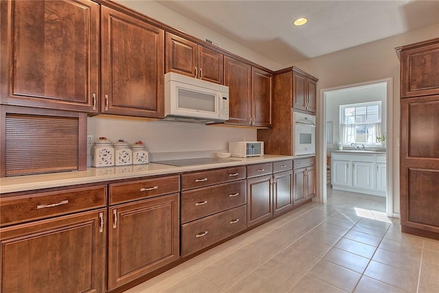 kitchen with recessed lighting, white appliances, light countertops, and light tile patterned flooring