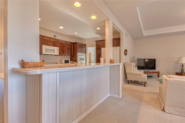 kitchen with recessed lighting, light colored carpet, visible vents, open floor plan, and white appliances