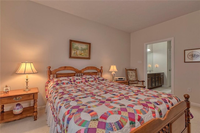 bedroom featuring baseboards, connected bathroom, and light colored carpet