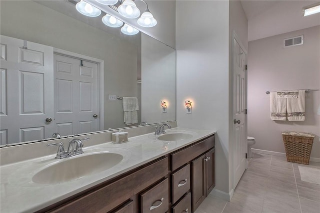 bathroom with visible vents, a sink, toilet, and double vanity