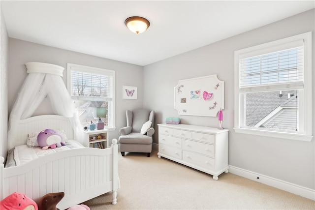 bedroom with light colored carpet and baseboards