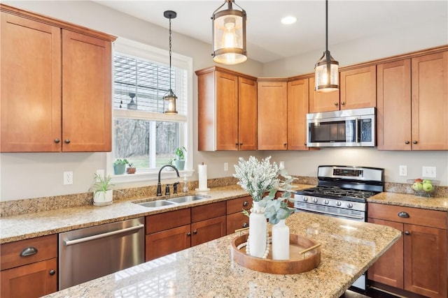 kitchen with a healthy amount of sunlight, appliances with stainless steel finishes, a sink, and decorative light fixtures