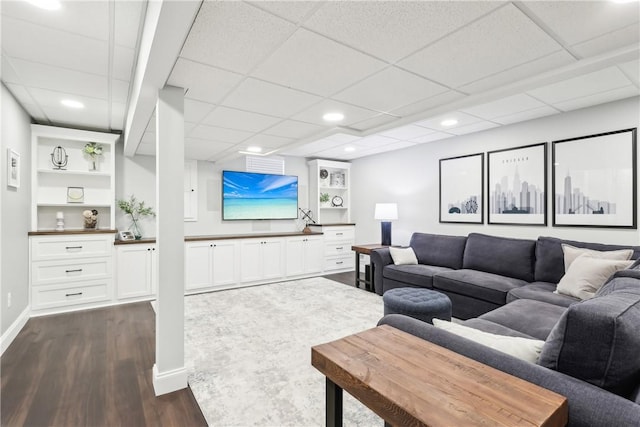 living room with built in shelves, baseboards, dark wood finished floors, and recessed lighting