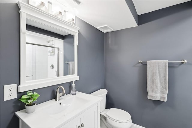 full bathroom with tiled shower, vanity, and toilet