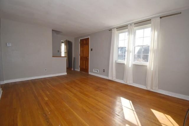 unfurnished room with baseboards and wood finished floors