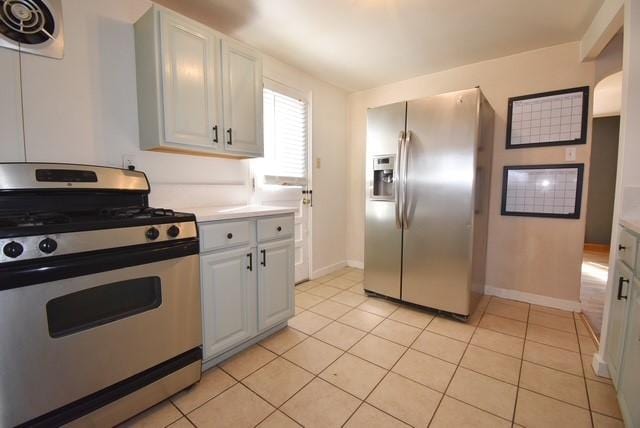 kitchen with light tile patterned floors, baseboards, visible vents, stainless steel appliances, and light countertops