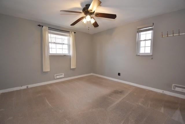 carpeted empty room with plenty of natural light, baseboards, and ceiling fan