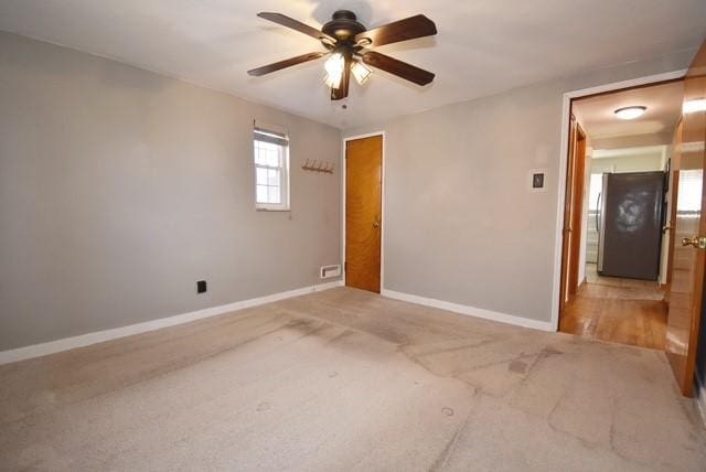 empty room with baseboards, a ceiling fan, and carpet flooring