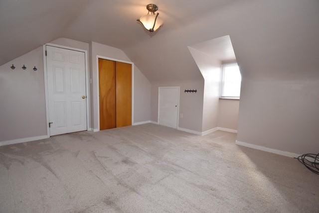 bonus room with lofted ceiling, carpet flooring, and baseboards