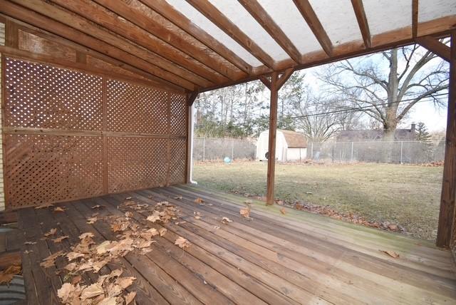 deck featuring a yard, a shed, an outdoor structure, and a fenced backyard