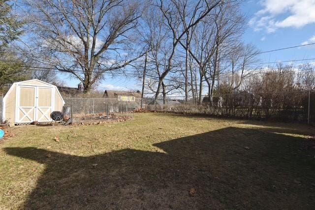 view of yard with a fenced backyard, an outdoor structure, and a shed