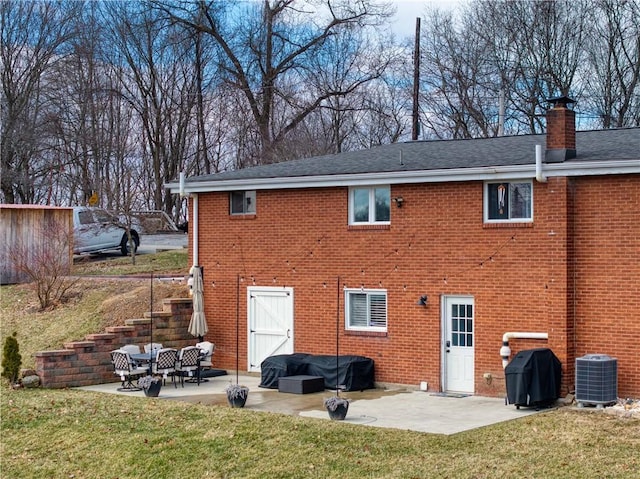 back of property with a patio area and brick siding