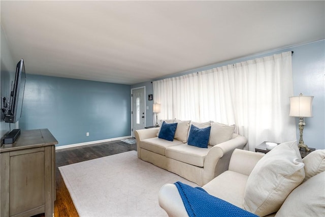 living room featuring baseboards and dark wood-style flooring