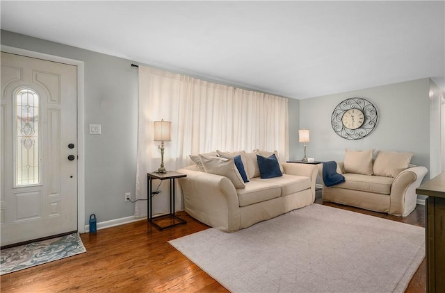 living area with baseboards and wood finished floors