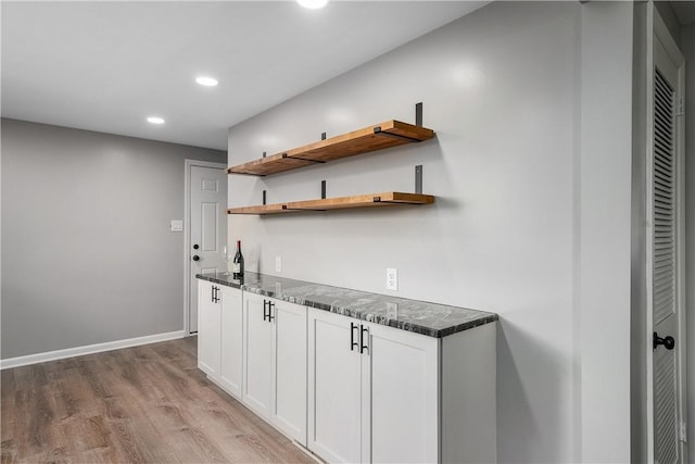 bar featuring light wood-type flooring, baseboards, and recessed lighting