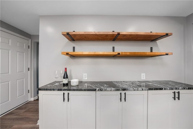 kitchen with open shelves, dark wood-style floors, white cabinetry, and dark stone counters