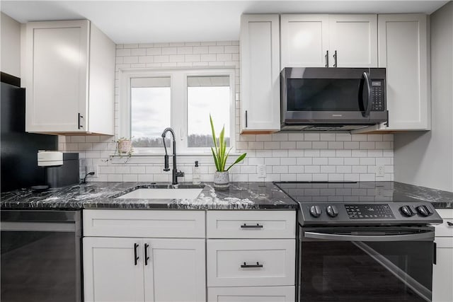 kitchen featuring a sink, white cabinets, stainless steel electric range, tasteful backsplash, and dark stone countertops