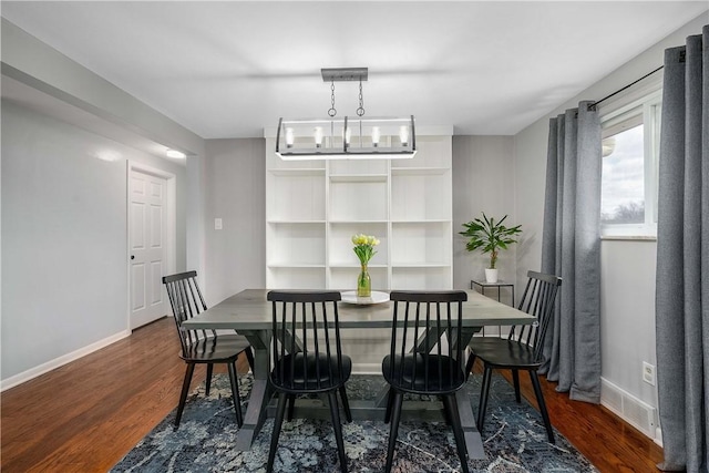 dining space with a chandelier, visible vents, dark wood finished floors, and baseboards