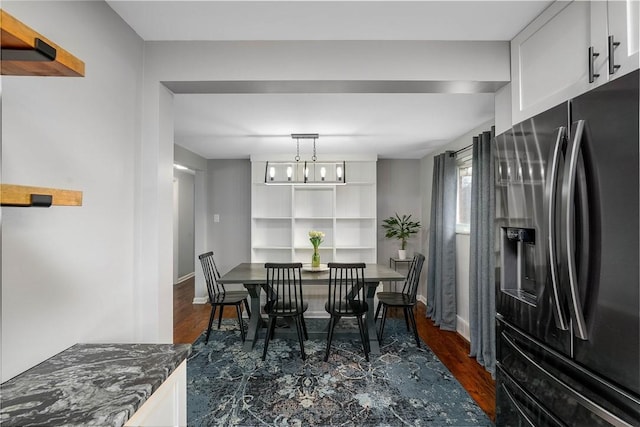 dining room with dark wood-style floors, baseboards, and a notable chandelier