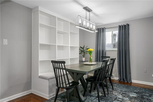 dining space featuring baseboards and dark wood finished floors