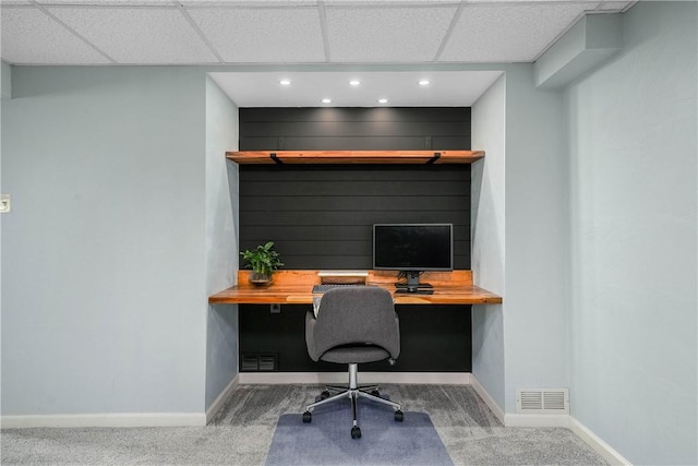 carpeted home office with visible vents, built in desk, and baseboards