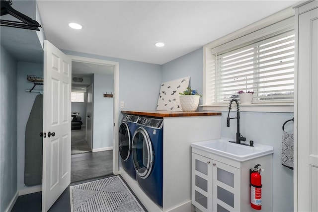 laundry area featuring a sink, laundry area, plenty of natural light, and washing machine and dryer