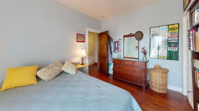 bedroom with baseboards and wood finished floors