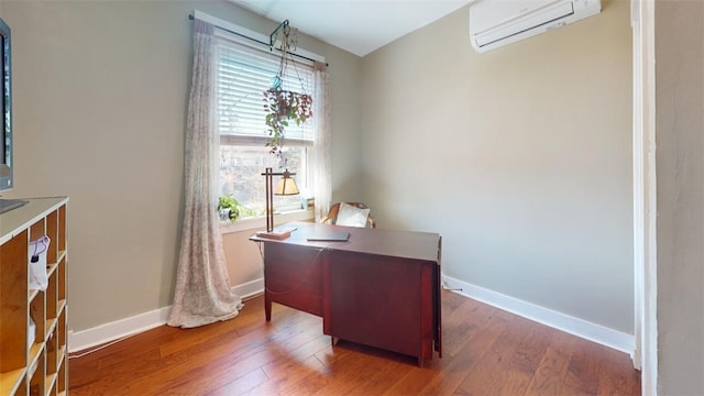 office with a wall mounted air conditioner, baseboards, and wood finished floors