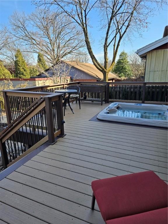 deck with an outdoor hot tub