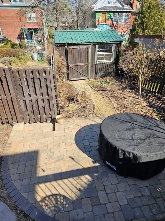 view of patio / terrace featuring a storage shed, a fenced backyard, and an outdoor structure