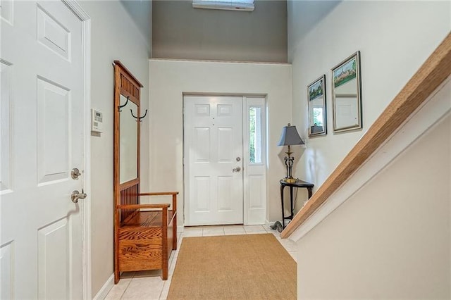 foyer entrance featuring light tile patterned floors and stairway