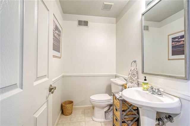 half bathroom featuring toilet, tile patterned flooring, and visible vents