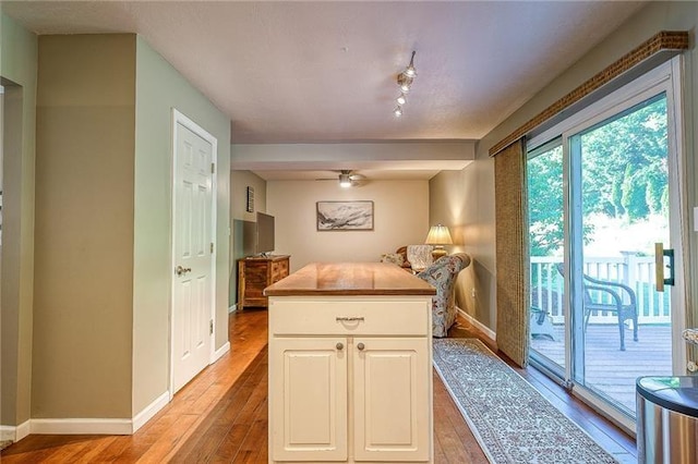 kitchen featuring light wood-type flooring, white cabinetry, and baseboards