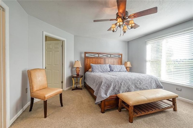 bedroom with light colored carpet, ceiling fan, and baseboards