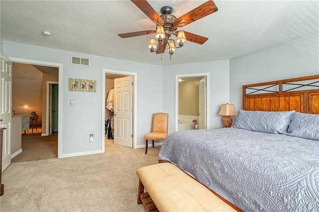 bedroom featuring a walk in closet, visible vents, a ceiling fan, light carpet, and baseboards