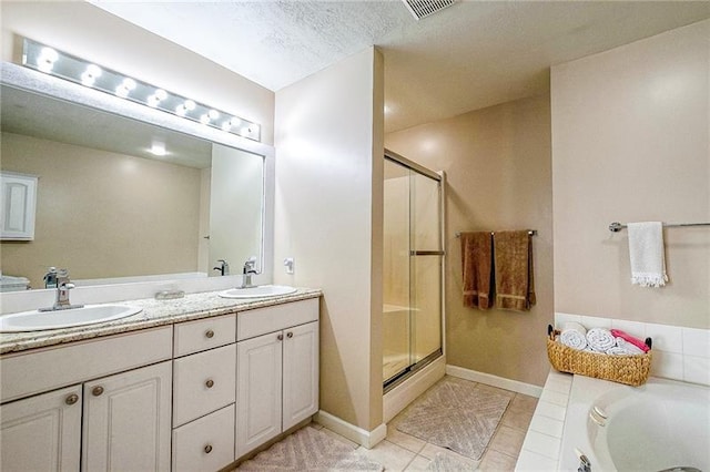 full bathroom featuring tile patterned floors, a sink, a shower stall, and a bath